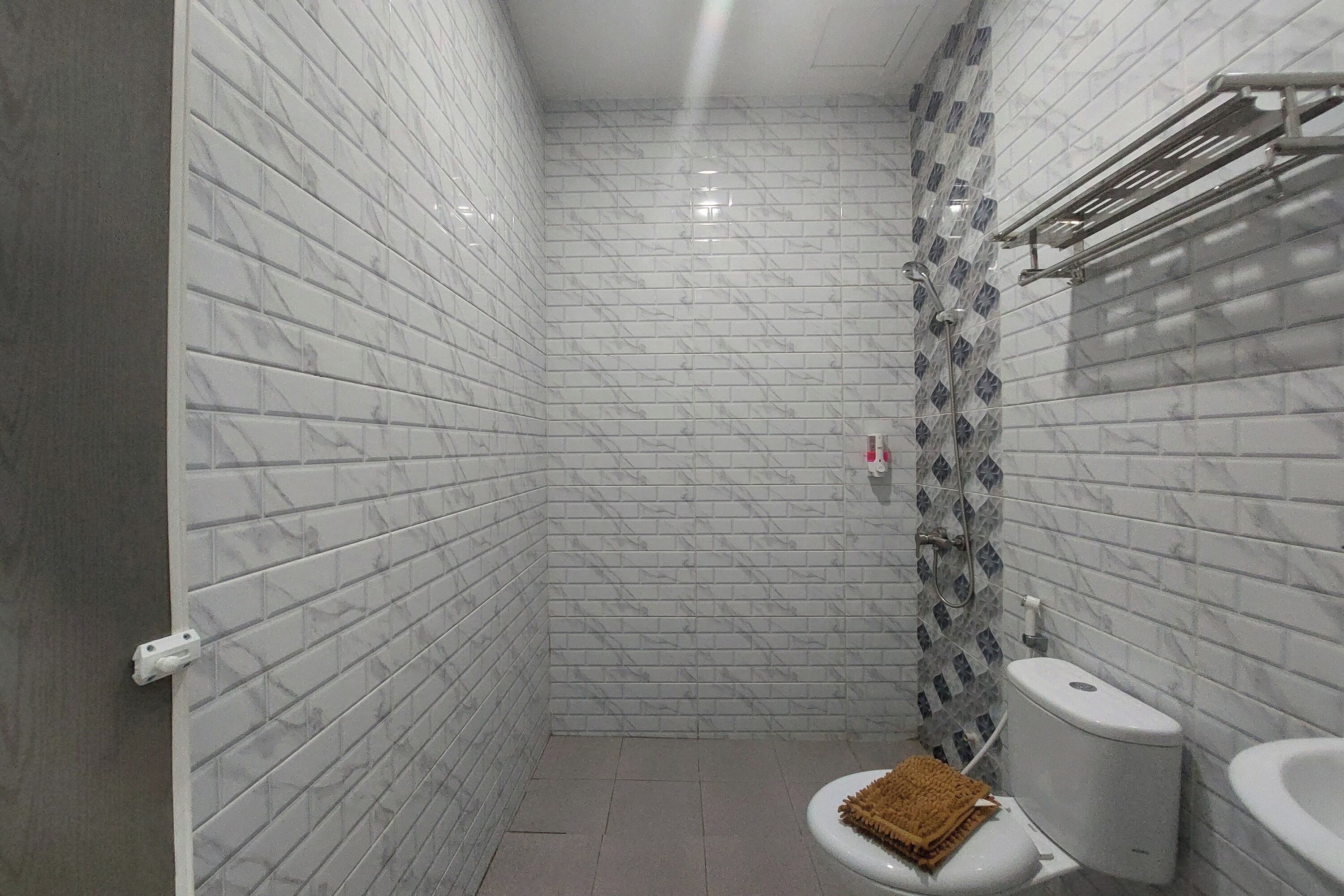 A small, tiled bathroom with a toilet, bidet, and shower area.