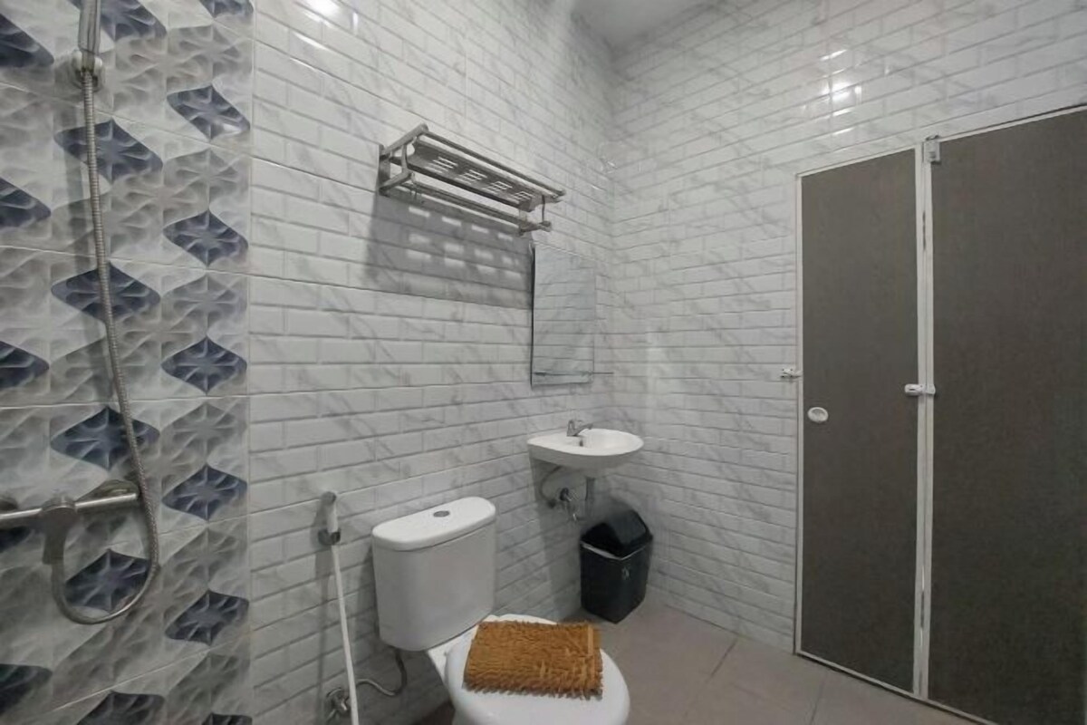 A bathroom with a toilet, sink, and shower.