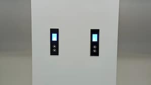 Two elevator control panels with illuminated buttons and a display screen. - Riverdale Cikarang By Veto Rooms (Cikarang)