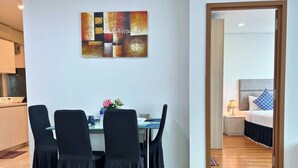 Un espace repas comprenant une table, des chaises et un tableau accroché au mur.