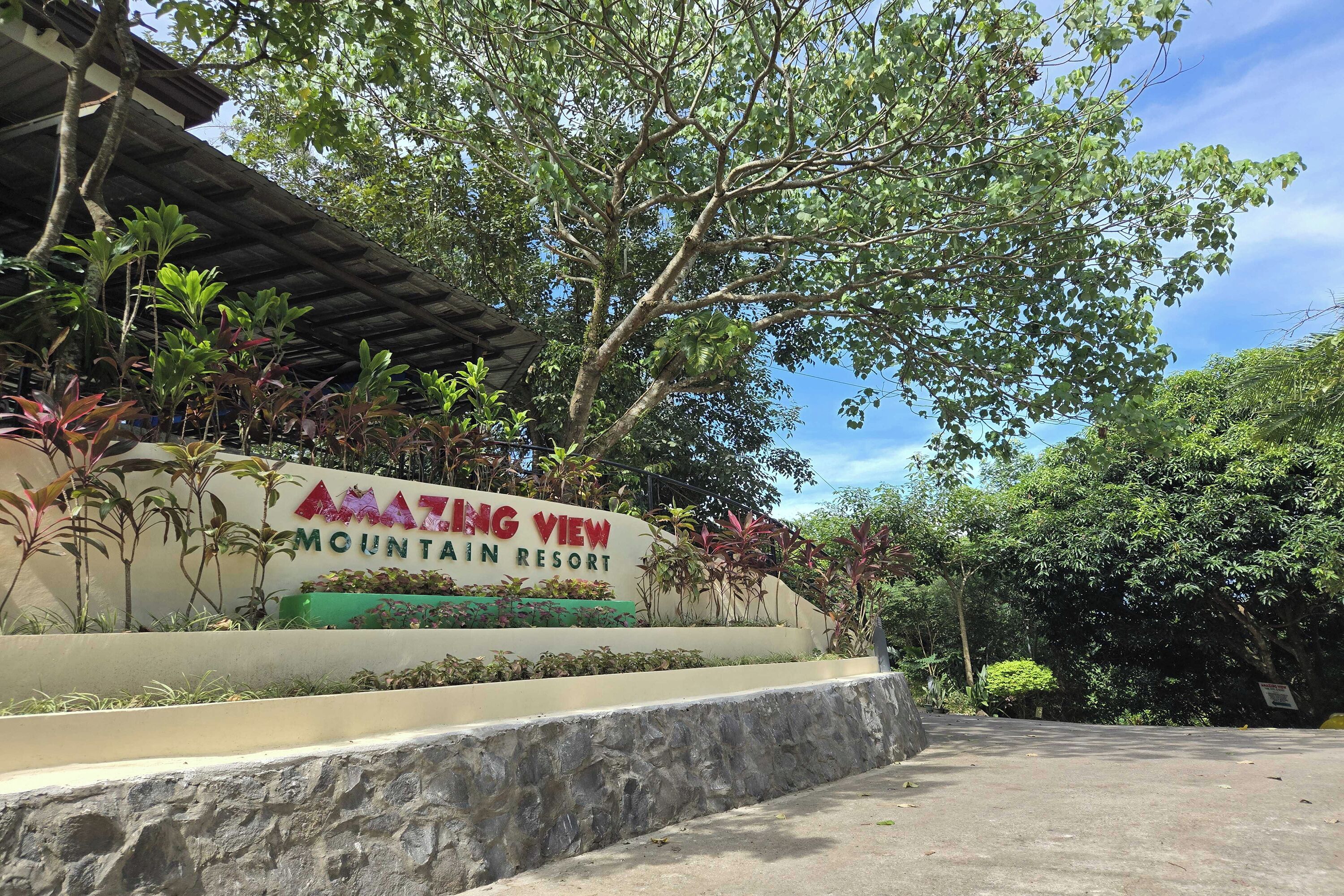 A sign for Amanting View Mountain Resort surrounded by lush greenery.