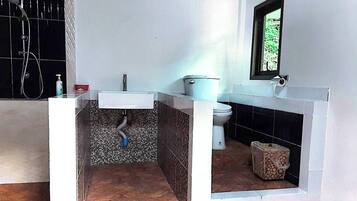 A bathroom with a white sink, toilet, and shower area.