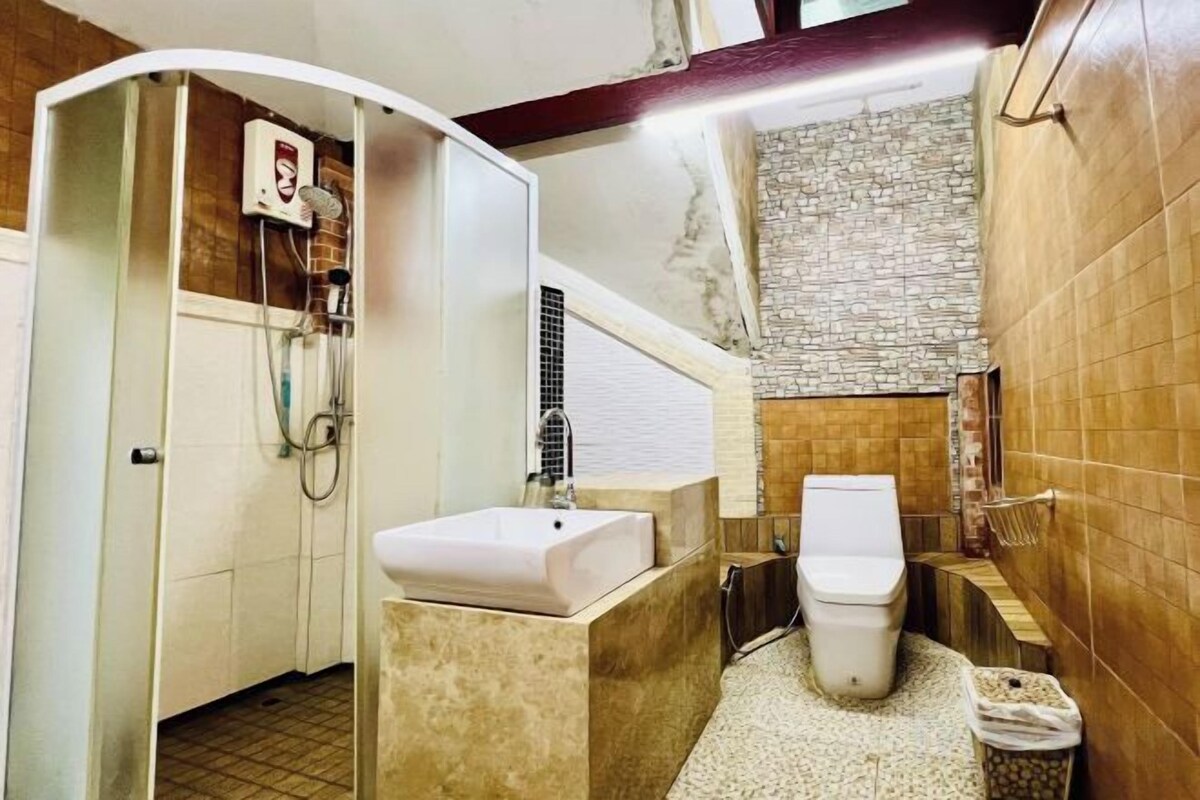 A compact bathroom with a shower, toilet, and sink.