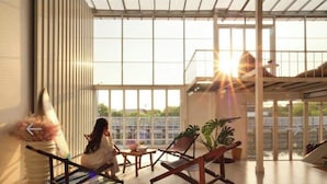 A spacious indoor area with large windows, a seating area with chairs and a table, and a view of the outdoors.