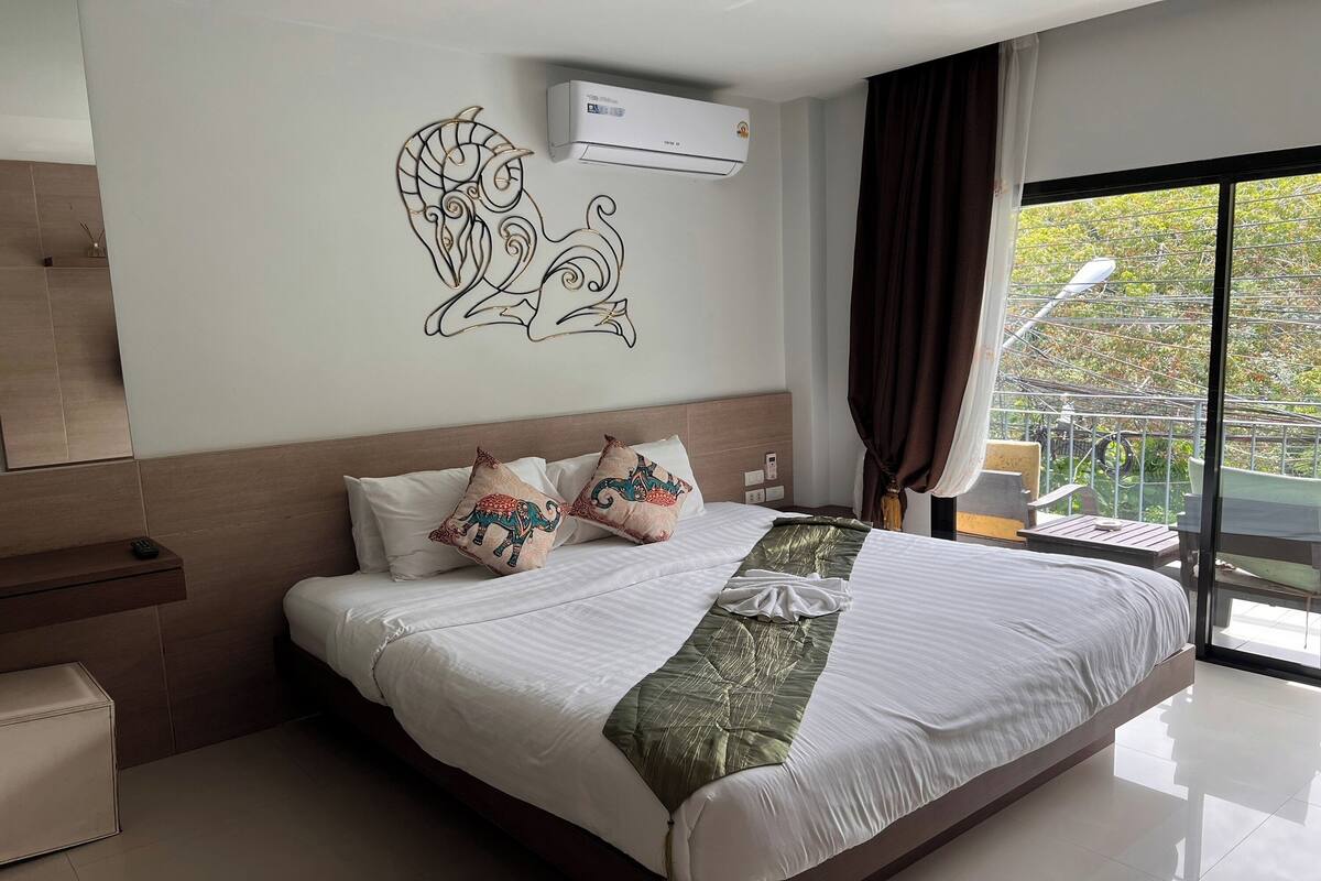 Habitación de hotel con una cama grande, aire acondicionado de pared y vistas al exterior.