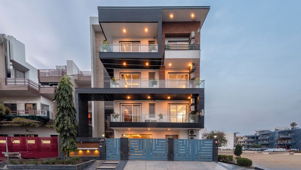 A modern multi-story residential building with balconies, large windows, and a gated entrance. - Saavi Hotel Sector- 46 (Gurugram)