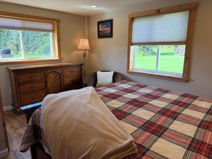 A bedroom with a bed, a dresser, a window, and a lamp. - Red Barn Retreat - Renovated Barn w/ huge patio near to CDP (Milford)