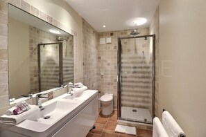A modern bathroom with a glass shower enclosure, a double sink vanity, and a toilet. - Le Mas de l'Esclat - Piscine - Luberon (Apt)