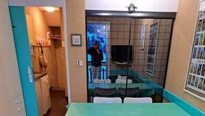 Ett kompakt bostadsutrymme med ett litet kök, ett matbord med stolar och en soffa.