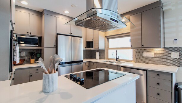 Una cocina moderna con una isla central, electrodomésticos de acero inoxidable y un diseño elegante.