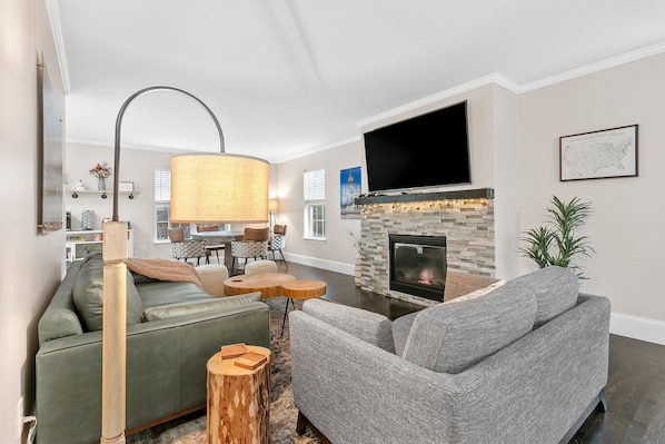 Una sala de estar con chimenea, televisor y sofá.