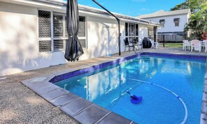A swimming pool with a tiled edge, a covered patio area, and a building labeled 'Seahaven' in the background.