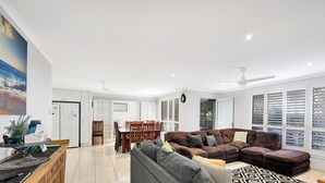 Un espacio habitable amplio con una mesa de comedor, sofás y una zona de cocina con refrigerador.