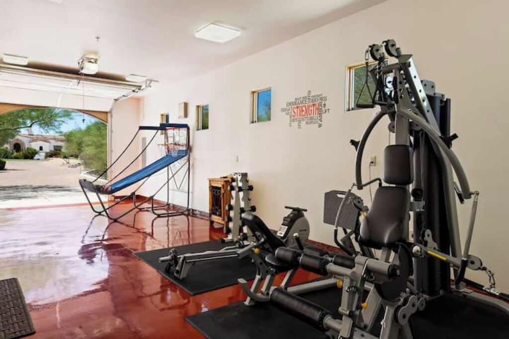 A gym with exercise equipment, a blue chair, and a motivational wall.