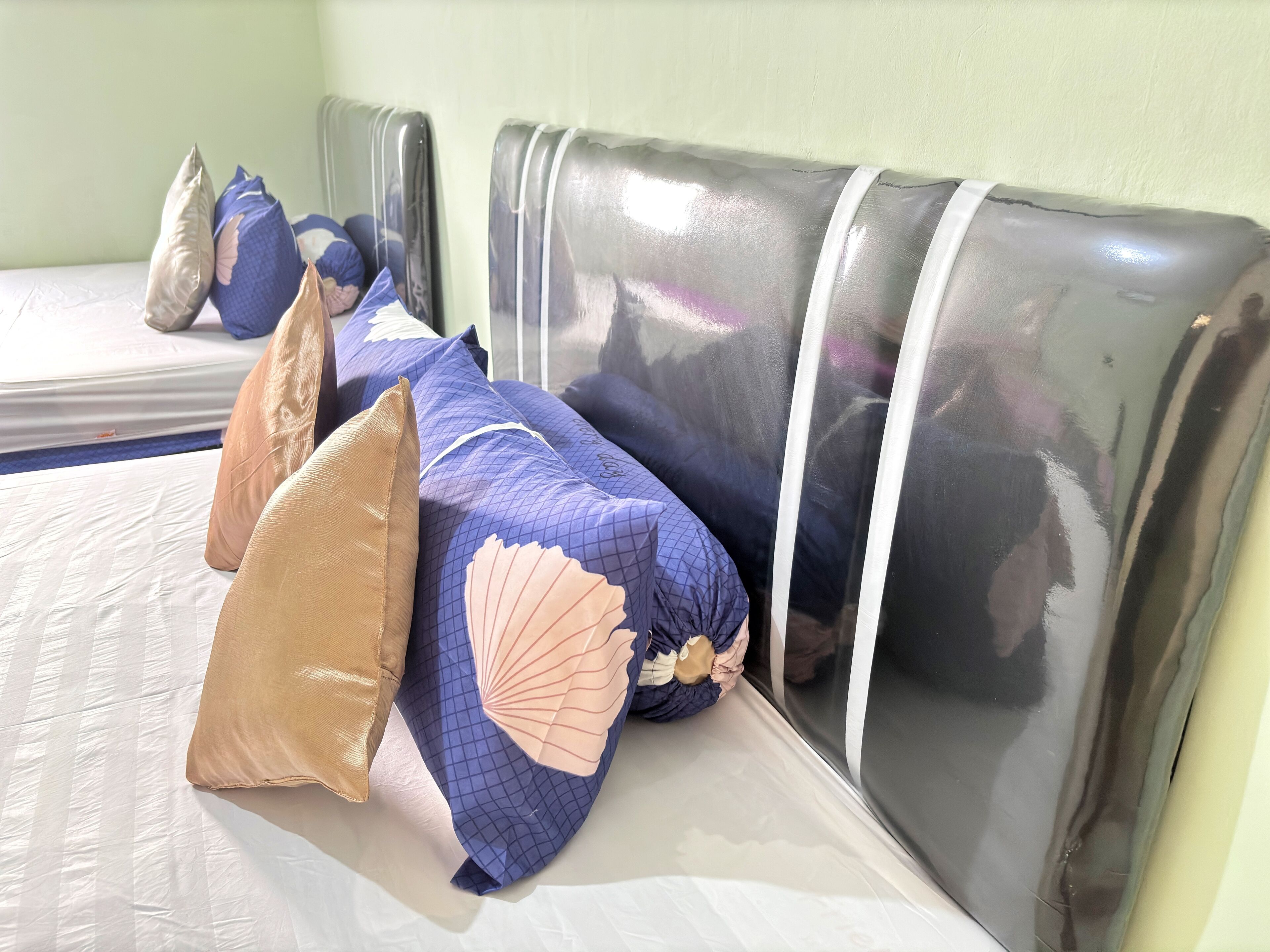 A hotel room with a bed, pillows, and a headboard.