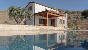 A modern house with a pool, stone walls, and wooden pergola. - Villa Eos  (Castellammare del Golfo)