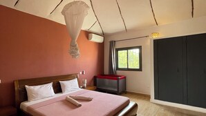 Un dormitorio con una cama de madera, una mesita de noche, una ventana con cortinas y un armario.