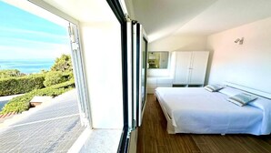 A bedroom with a large window, a bed, a wardrobe, and a view of the outdoors. - Villa Sapphires 94 (Plemmirio)