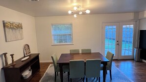 A dining room with a wooden table, four chairs, a rug, a bench with a decorative item, a window with blinds, and a ceiling light fixture. - Walking distance to the Stadium! Charming 3-bedroom house in lovely Norman (Norman)