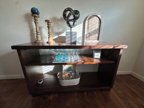 A wooden desk with a glass top, a cityscape model, and a decorative item.