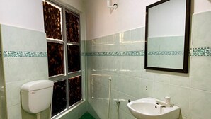 Un baño con inodoro, lavabo y ventana.