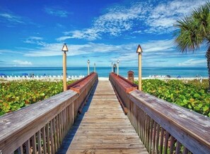 A wooden boardwalk leading to a beach with clear skies and calm waters. - Seychelles ala SkyRun elegance (Naples)