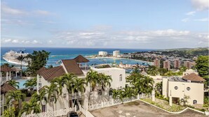 A coastal resort with a large cruise ship docked, a swimming pool, and a view of the ocean and cityscape. - Cozy 1-bedroom apartment in Ocho Rios stunning views of the Caribbean sea. (Ocho Rios)