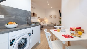Un espacio habitable compacto con cocina, comedor y una pequeña sala de estar.