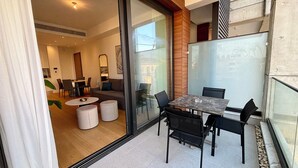 A modern interior with a dining area, a sofa, and a glass partition.