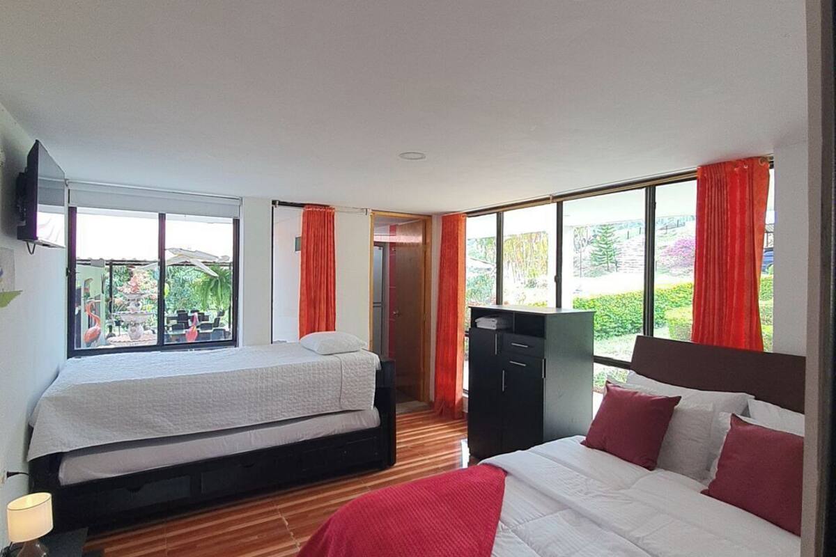 A hotel room with two beds, a wardrobe, and a TV.