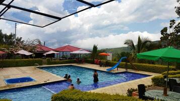 Una piscina al aire libre, sillones reclinables de piscina