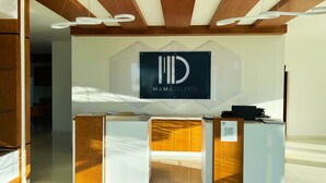 Un comptoir d’accueil orné du logo de l’hôtel Mamá Dolores, un comptoir d’accueil en bois et un code QR donnant accès aux informations sur l’hôtel.