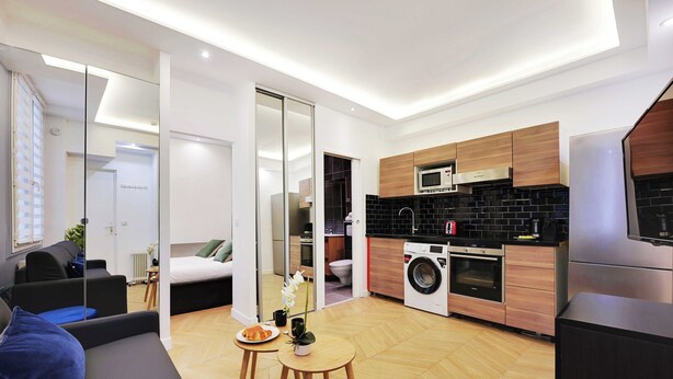 Un appartement moderne comprenant un salon, une cuisine et une chambre.