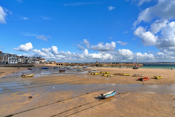 Una playa con barcos y un muelle.