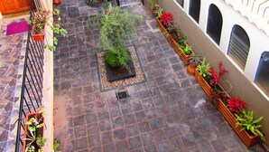 A multi-level courtyard with potted plants and a staircase. - L'Aurora Residencial Cusco (Cusco)