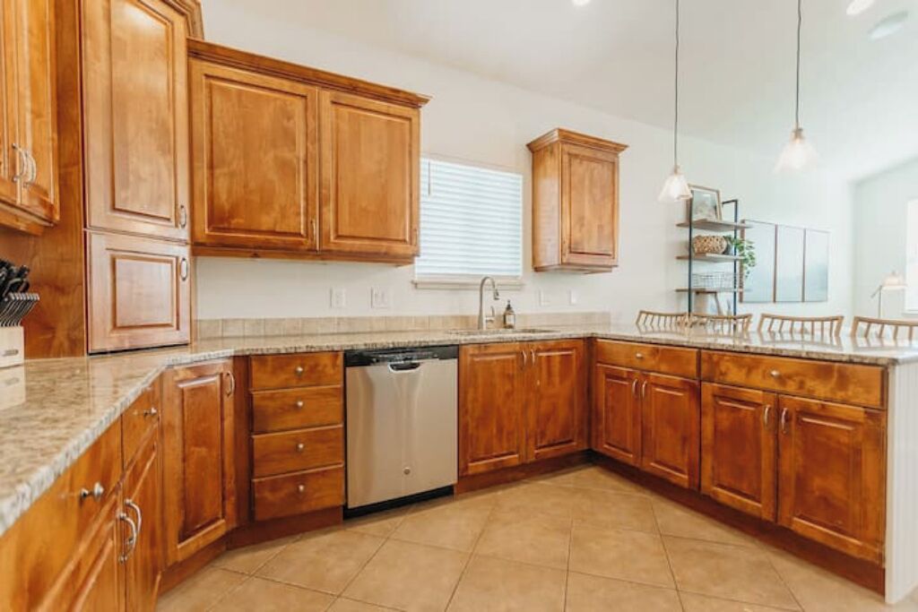 Una cocina con gabinetes de madera, lavavajillas y encimera.
