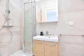 Appartement | Badkamer | Een haardroger, handdoeken, shampoo