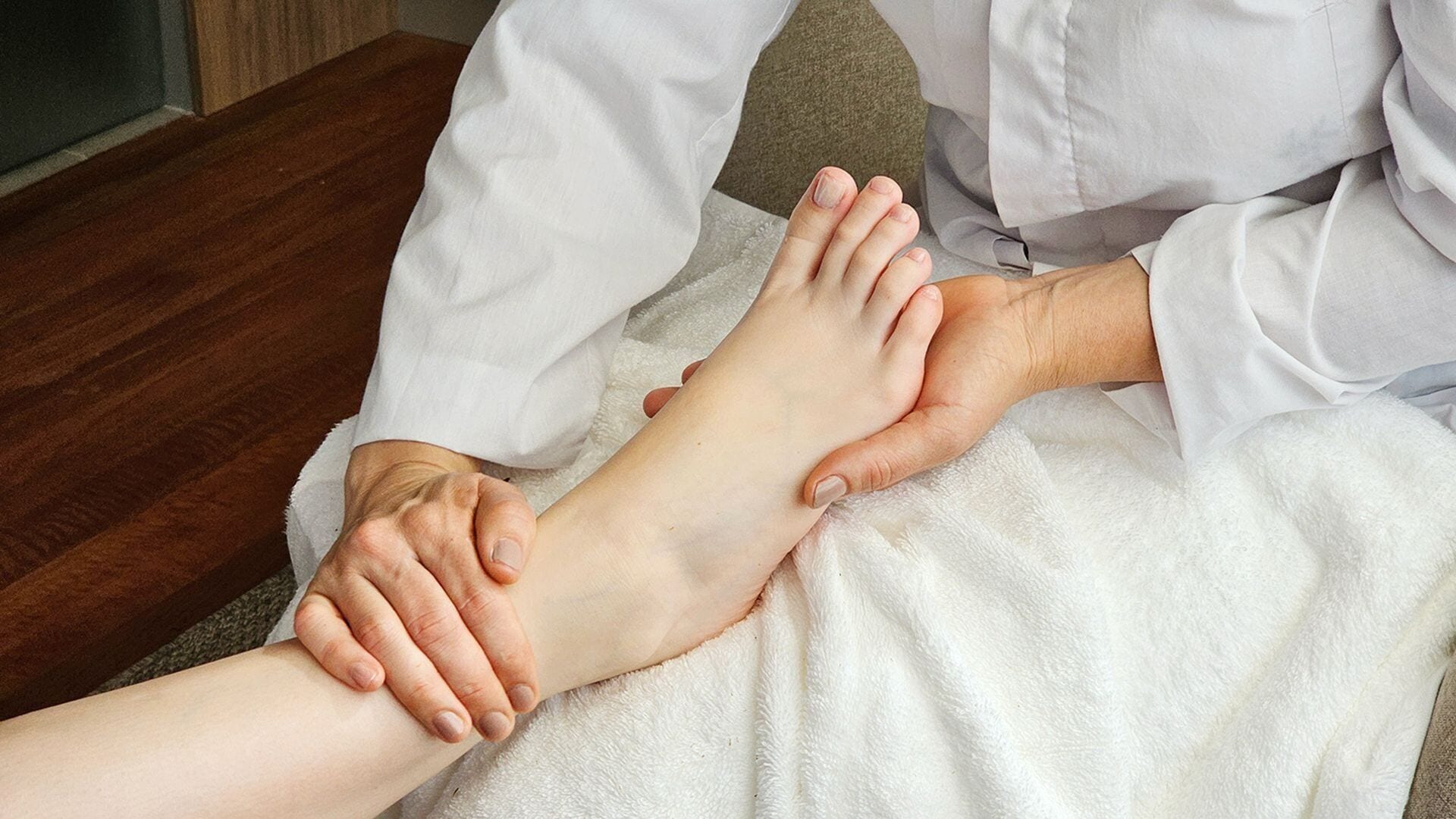 A foot massage session with a professional and a client.