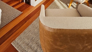 Ein kompakter, moderner Wohnraum mit Holzboden, einer integrierten Weinschlange, einer kleinen Küche mit Mikrowelle und einer Sitzecke mit gepolstertem Sessel und einer Lampe.