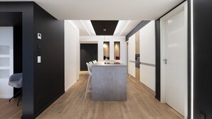 A modern kitchen with a central island, wooden flooring, and built-in appliances. - L'Esplanade ⭐️⭐️⭐️⭐️ (Metz)