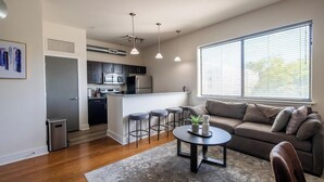 Una cocina moderna con armarios oscuros, una isla central e iluminación colgante.