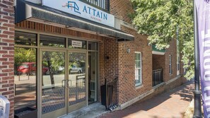 A brick building with a storefront labeled 'ATTAIN' and a sign indicating '1903 EAST MARSHALL'.