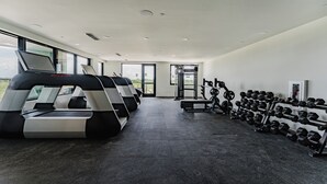 A gym with treadmills, a weight bench, and a rack of dumbbells.