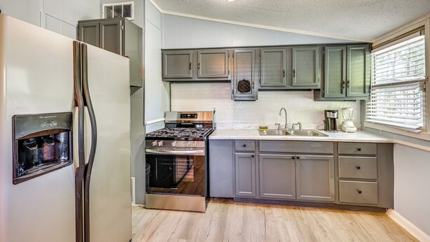 Una cocina equipada con refrigerador, estufa, horno y lavaplatos.