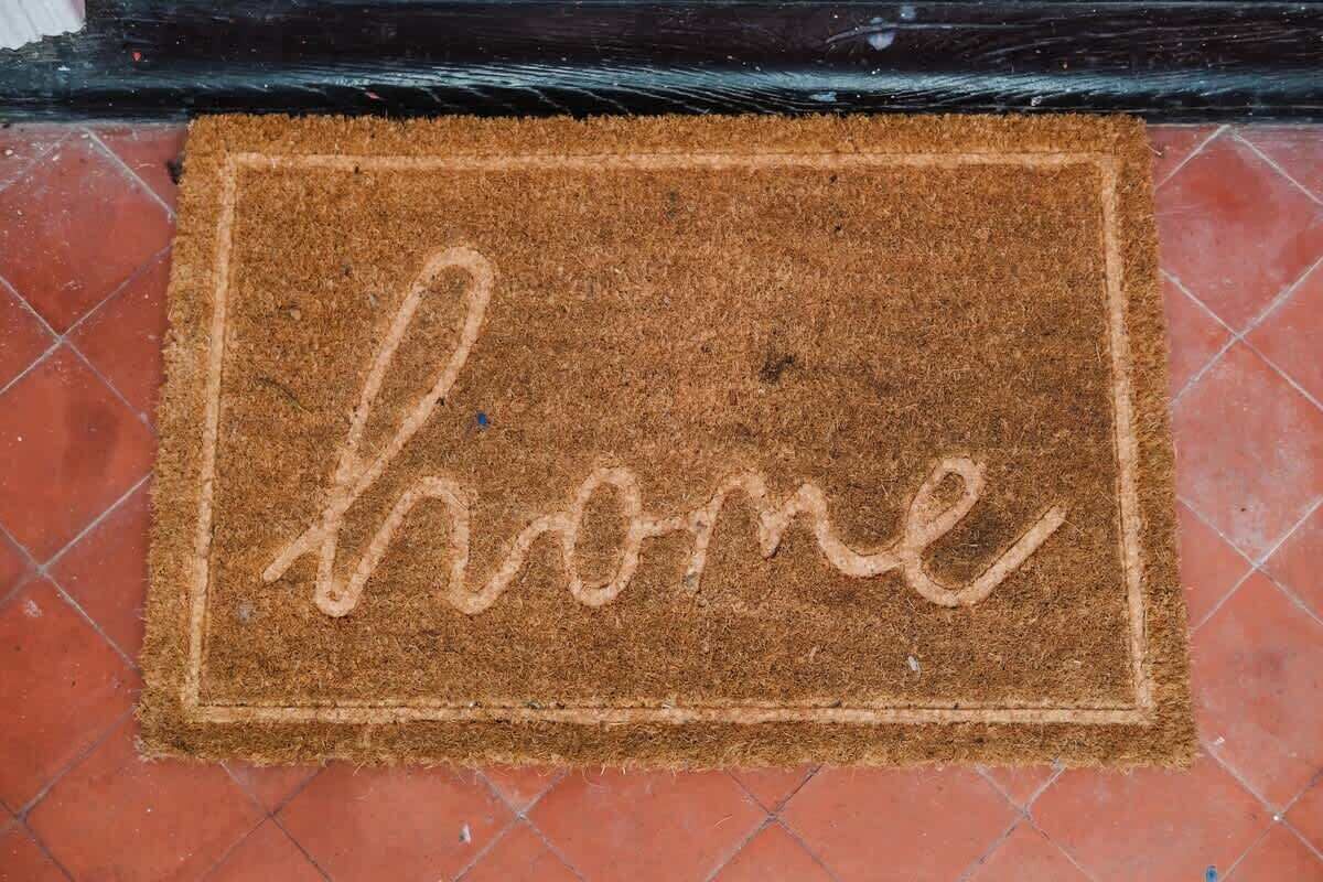 Una felpudo marrón con la palabra 'home' escrita en él.
