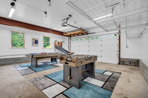 Amplio espacio interior con mesa de fútbol de mesa, mesa de ping pong y aro de baloncesto.