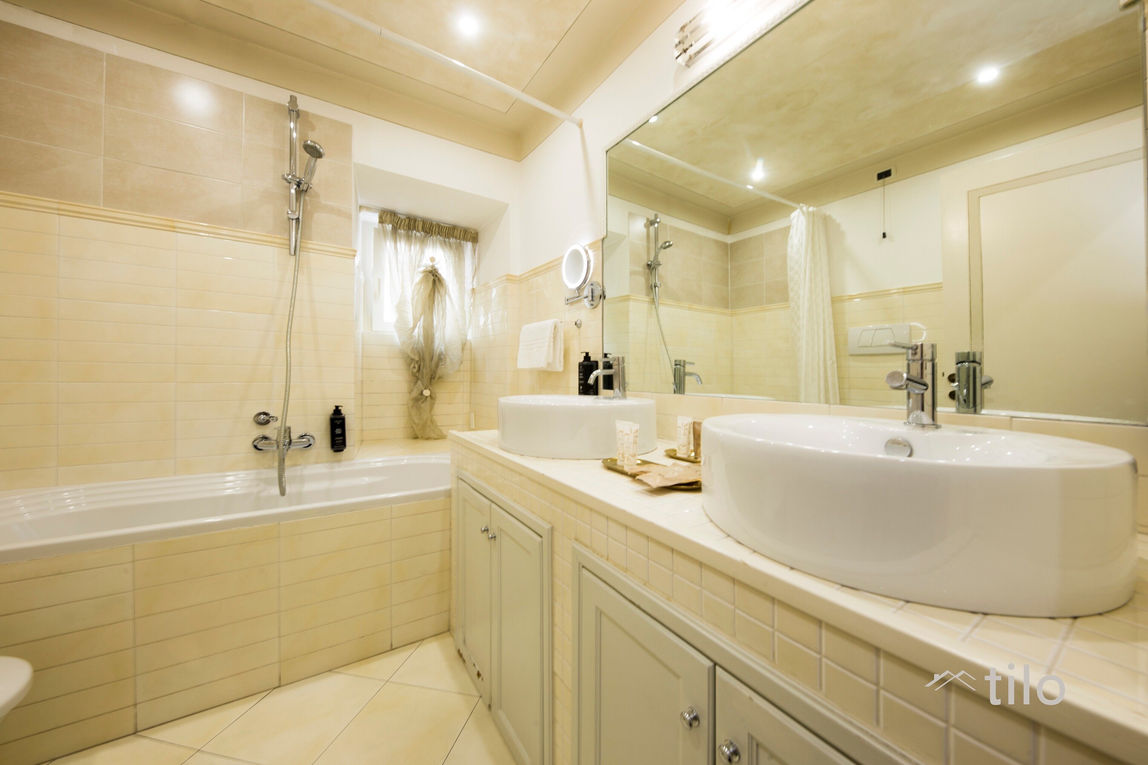 A modern bathroom with a large bathtub, a round sink, and a mirror above the sink.