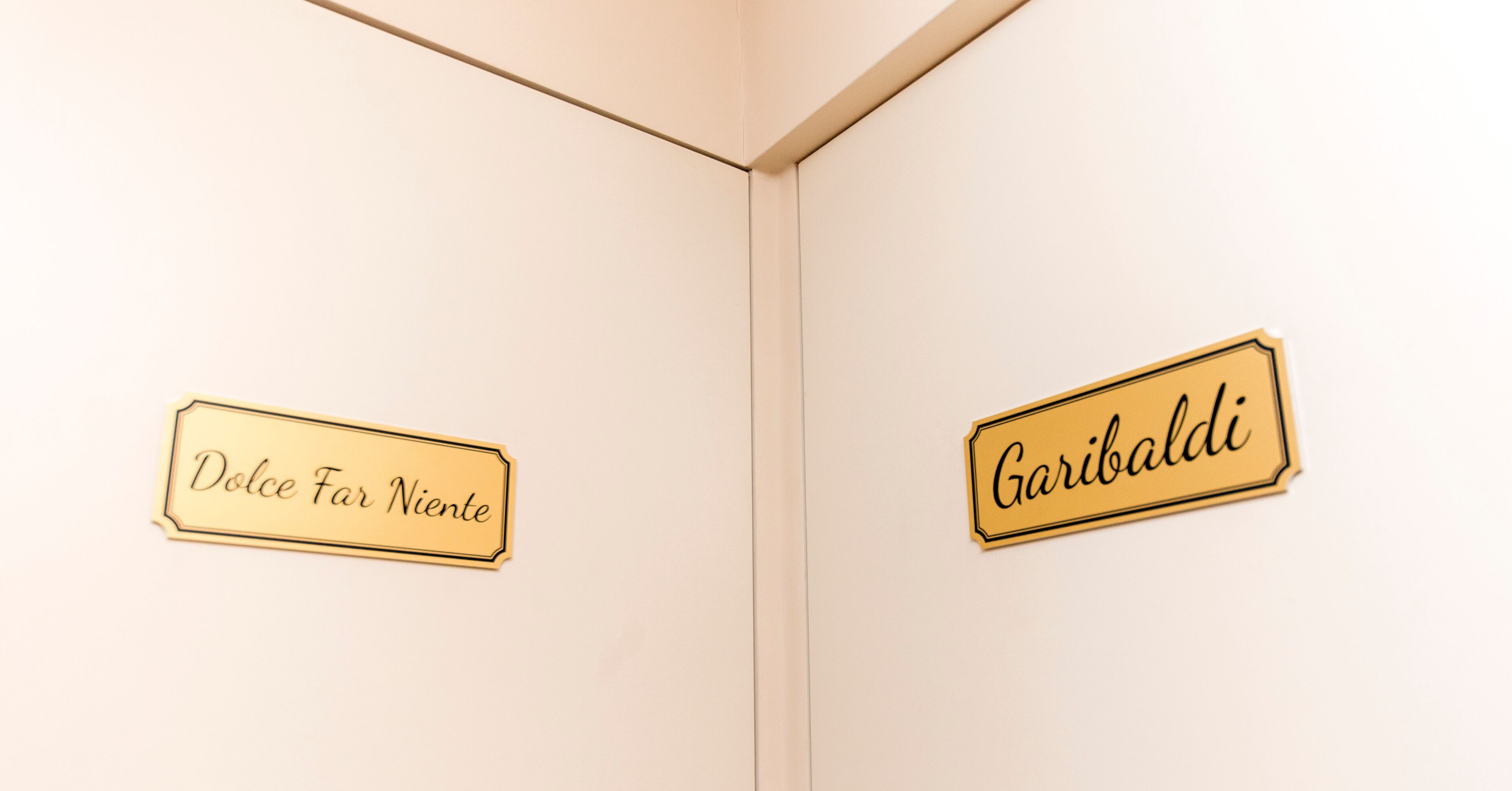 Two signs on a wall, one reads "Dolce Far Niente" and the other "Garibaldi".