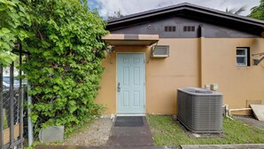 A house with a light blue door, an air conditioning unit, and a small window. - 8 Mi to Beach: Pet-Friendly Fort Lauderdale Studio (Fort Lauderdale)