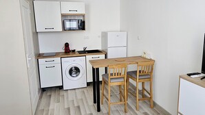 A compact living space with a kitchenette, a dining area, and a seating area.